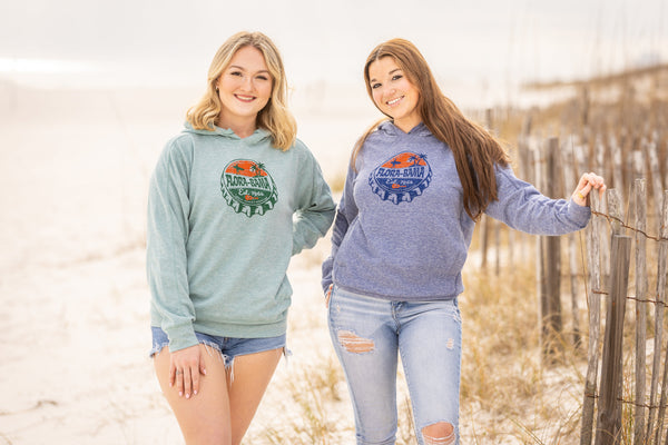 two girls on the beach wearing green and blue sweatshirt