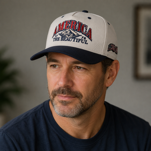 Man wearing a cap with 'America the Beautiful' text in an indoor setting and flora bama logo on the side