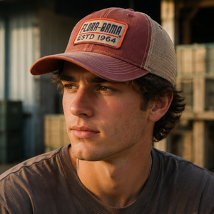 Man wearing a maroon and beige cap with 'Flora-Bama' logo, sitting outdoors.