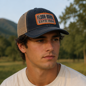 Man wearing a denim cap with 'Flora-Bama' logo in a natural setting