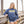 Woman wearing a blue hoodie with 'Flora-Bama' text, standing on a wooden deck.