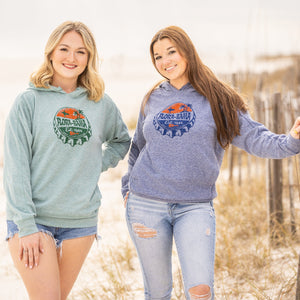 two girls wearing a blue and a green hoodie sweatshirt with bottlecap drawing on front with flora bama text and palm tree