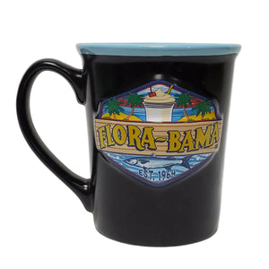 A black coffee mug with a colorful bushwacker graphic and logo 'Flora-Bama' on the front.