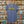A blue Flora-Bama brand t-shirt with a wavy yellow logo on the front hanging on license plates