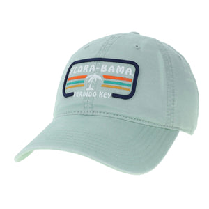 A light blue Flora-Bama cap with a curved visor and a patch on the front featuring the Flora-Bama text in white with a palm tree and colored lines