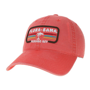 A pink Flora-Bama cap with a curved visor and a patch on the front featuring the Flora-Bama text in white with a palm tree and colored lines