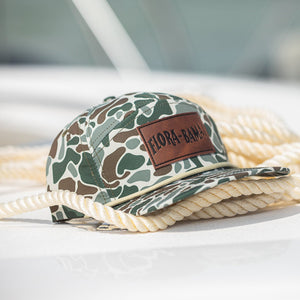Camouflage cap with leather patch on a boat with ropes