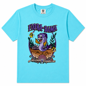 A bright blueshort-sleeve crewneck t-shirt featuring a colorful graphic print on the front. The graphic displays a purple sea turtle, yellow tropical fish, and the text 'FLORA-BAMA' and 'ON THE FLORIDA - ALABAMA LINE!'.