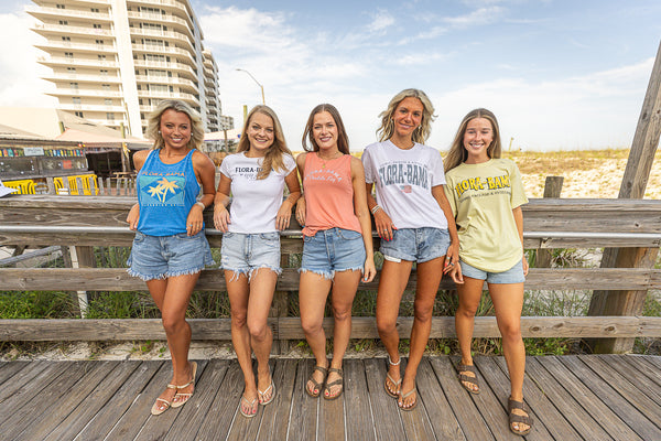 girls on boardwalk wearing flora bama assortment of shirts