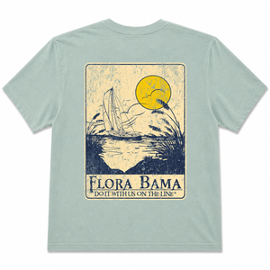 Light blue t-shirt with a graphic design of a sailboat and text 'Flora Bama' on a white background