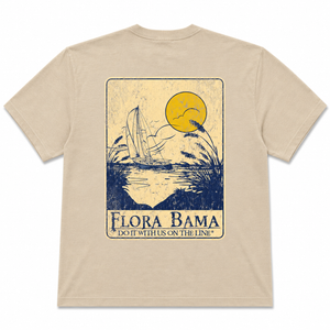 Beige t-shirt with a graphic design of a sailboat and sunset, featuring the text 'Flora Bama'.
