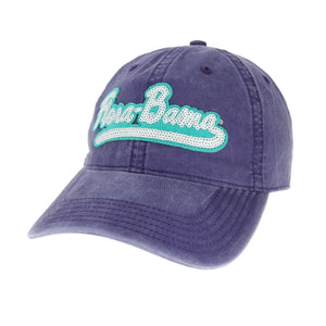A purple baseball cap with 'Flora-Bama' written in teal sequins on the front.