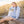 woman sitting on a boardwalk in light gray hoodie sweatshirt with beach scene and flora bama across the front center