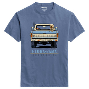 Blue t-shirt with a graphic of a truck and dog, featuring 'Flora-Bama' text, on a white background.