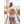 Person wearing a peach t-shirt with a graphic design, standing on a wooden boardwalk by the beach.