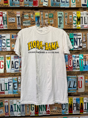 A white Flora-Bama brand t-shirt with a wavy yellow logo on the front hanging on license plates