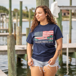 Navy blue t-shirt with American flag and palm tree design and flora bama text below