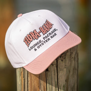 white cap with pink bill and pink embroidered flora bama logo on front