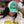 Person wearing a teal hat with mesh background and flora bama script embroidered text on the front