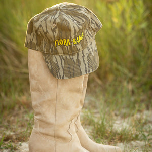 Camouflage hat with 'Flora-Bama' logo on a boot against a natural background