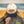 Person wearing a cap with 'America the Beautiful' design on a beach.