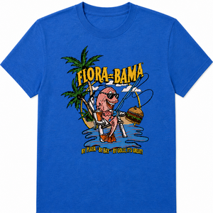 A royal blue short-sleeve crewneck t-shirt featuring a colorful graphic print on the front. The graphic shows a cartoon pink fish wearing sunglasses and holding a beach umbrella next to a hamburger, with palm trees and the text 'FLORA=BAMA' and 'BY PLAIN - BY BAY - BY GULLITY - OVERLY' in yellow and black.