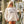 woman wearing white mockneck sweatshirt with flora bama perdido key text across the front