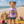 child on the beach in a white t-shirt with 'My First Flora-Bama' printed in blue and yellow lettering, featuring an anchor graphic and text.
