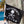Black flag with 'No Shoes Nation' text and skull design hanging on a wooden post by a poolside.