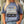 Person wearing a blue t-shirt with a graphic of a truck, dog and 'Flora-Bama' text.