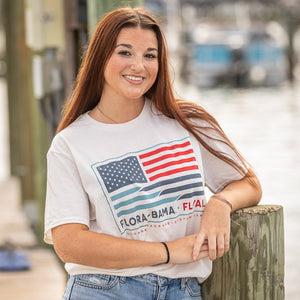 Woman wearing a t-shirt with an American flag design by a dock