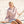 Woman sitting on a rope at the beach wearing a light pink sweatshirt with flora bama  text.